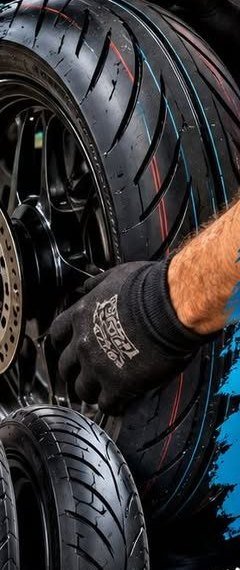 Un mécanicien monte un pneu neuf sur une jante de deux-roues